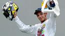 Pebalap MotoGP asal Italia, Valentino Rossi mengangkat helm merayakan gelar juara di Sirkuit Sepang, Malaysia, Minggu (12/10/2003). (AFP/Jimin Lai)