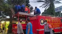Petugas pemadam kebakaran mengevakuasi jasad Dedi yang tewas tersengat listrik di atas pohon, di Jalan Halim PK, Kecamatan Batuceper, Kota Tangerang, Rabu (8/7/2020). (Liputan6.com/Pramita Tristiawati)