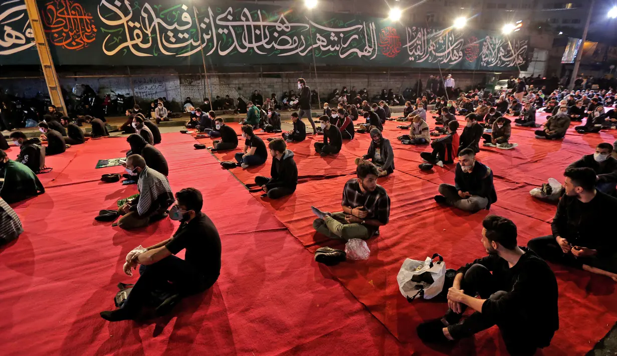 Warga Iran dengan mengenakan masker menghadiri acara kajian dan pengajian Lailatul Qadar, salah satu malam paling suci selama bulan Ramadan, di luar masjid di Teheran, Rabu (13/5/2020). Pemerintah Iran membuka kembali masjid-masjid untuk manyambut malam Lailatul Qadar. (ATTA KENARE/AFP)