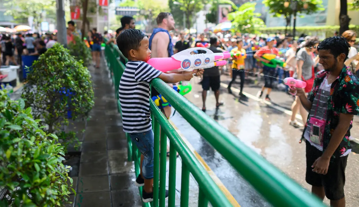 Warga saling menyemprotkan air saat merayakan Festival Songkran atau Tahun Baru Thailand di Bangkok, 14 April 2019. Setiap orang boleh menyemprotkan atau menyiram air kepada siapa pun. (Permata SAMAD/AFP)