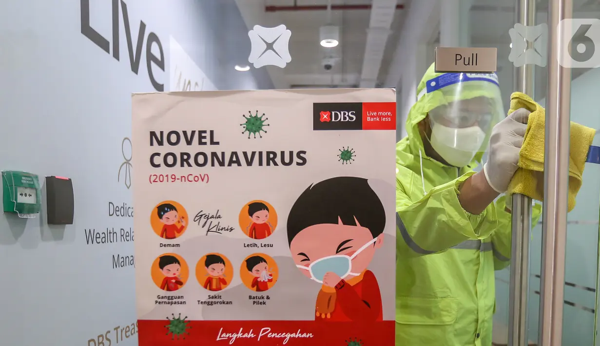 Petugas membersihkan gagang pintu di kantor DBS Tower, Jakarta, Selasa (30/6/2020). Bank DBS Indonesia menerapkan protokol kesehatan dengan penyemprotan cairan desinfektan dan melakukan pelapisan antimicrobial di area kantor untuk mencegah penyebaran virus Covid-19. (Liputan6.com/Fery Pradolo)