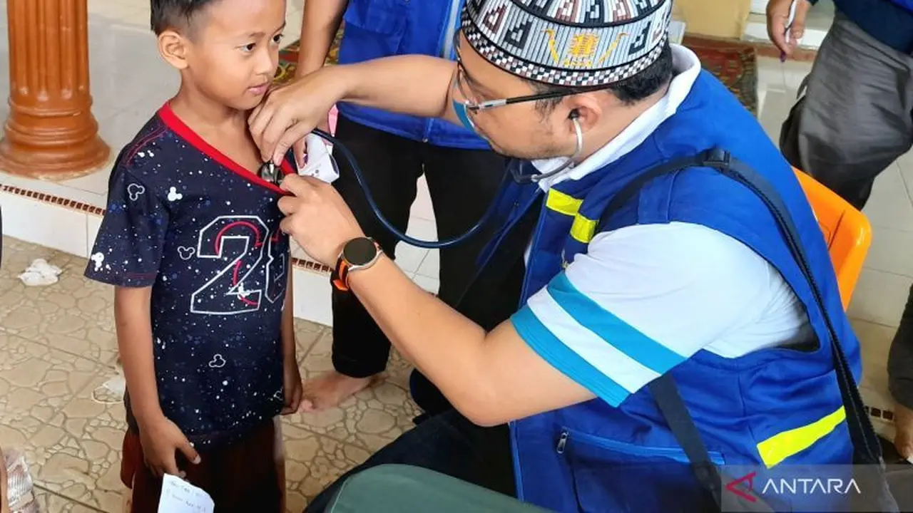 relawan kemenkes memberikan pengobatan kepada anak di Aceh Tamiang