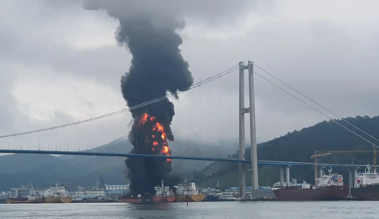 Api melahap kapal kargo di pelabuhan Ulsan, di pantai tenggara Korea Selatan (28/9/2019). Menurut pihak berwenang, sembilan pelaut terluka setelah kebakaran terjadi di kapal kargo dan menyebar ke kapal lain menyusul ledakan di kota pelabuhan tenggara Ulsan tersebut. (AFP/Yonhap)