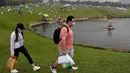 Sepasang suami istri melewati orang-orang yang berkemah di gunung yang indah di Yanqing, pinggiran Beijing, 30 Agustus 2020. China memiliki lebih dari 200 orang yang dirawat di RS karena COVID-19, dengan lebih dari 300 lainnya diisolasi usai dites positif terkena virus tanpa gejala. (AP/Andy Wong)