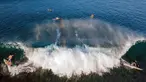 Pemandangan udara menunjukkan para peselancar menunggangi ombak di pantai Lhoknga, provinsi Aceh, pada Senin 12 Januari 2026. Indonesia merupakan negara kepulauan dengan kekayaan alamnya yang memukau. Salah satunya adalah Pantai Lhoknga di Kecamatan Lhoknga, Kabupaten Aceh Besar. (CHAIDEER MAHYUDDIN/AFP)