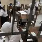 Siswa Sekolah Menengah Pertama Luar Biasa (SMPLB) Kategori B atau tunarungu saat mengerjakan Ujian Nasional Kertas Pensil (UNKP) di SLB Negeri 7 Jakarta, Selasa (24/4). UNKP di SLB tersebut diikuti oleh delapan peserta. (Merdeka.com/Iqbal Nugroho)