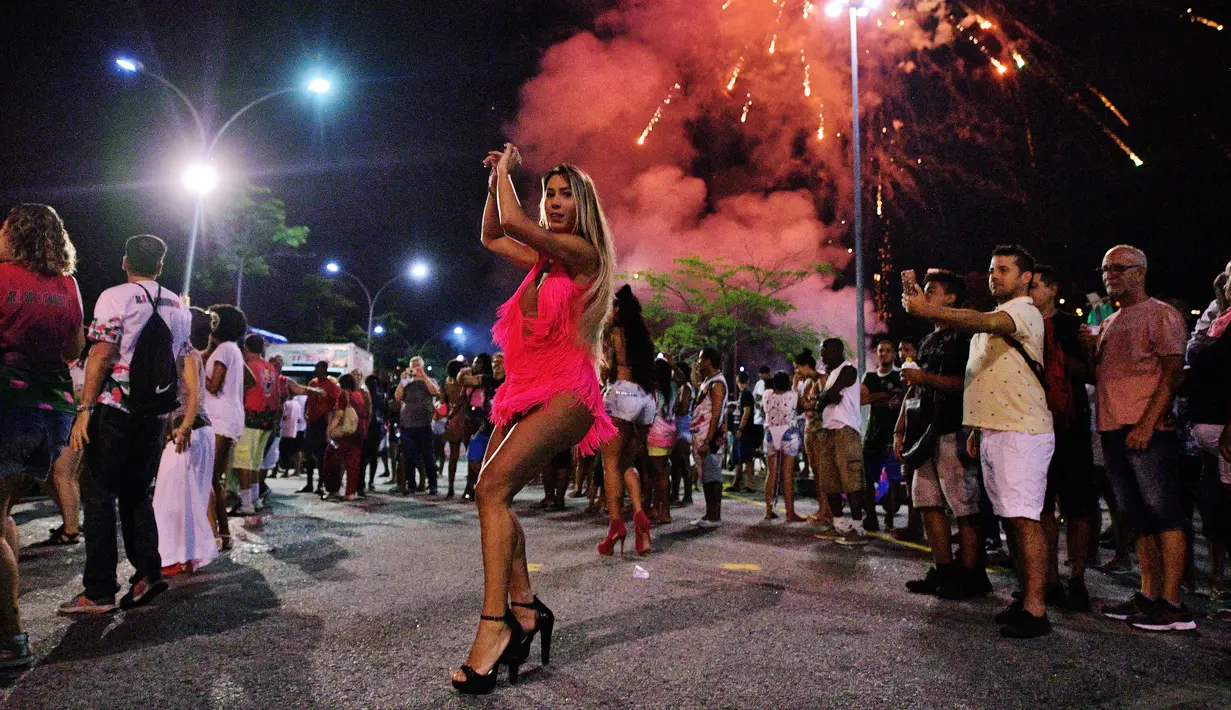 Seorang wanita menari selama sesi latihan oleh sekolah samba Mangueira di Rio de Janeiro, Brasil (21/2). Karnaval Rio de Janeiro akan berlangsung dari 2 Maret hingga 9 Maret 2019. (AFP Photo/Carl De Souza)