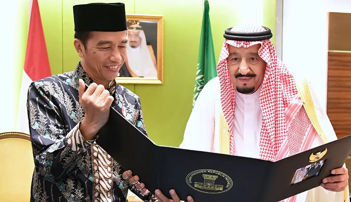 Presiden RI, Joko Widodo (Jokowi) memperlihatkan album foto dari pertemuan mereka di Bogor sehari sebelumnya untuk Raja Arab Saudi Salman bin Abdul Aziz di Jakarta, Kamis (2/3). (AFP PHOTO / PRESIDEN PALACE / Laily Rachev)