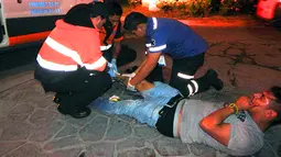 Petugas medis memberikan pertolongan kepada korban luka akibat penembakan di kelab malam Blue Parrot, Meksiko (16/1). Akibat penembakan tersebut, sedikitnya lima orang tewas dan belasan lainnya dilaporkan mengalami luka-luka. (AFP/Victor Vargas)