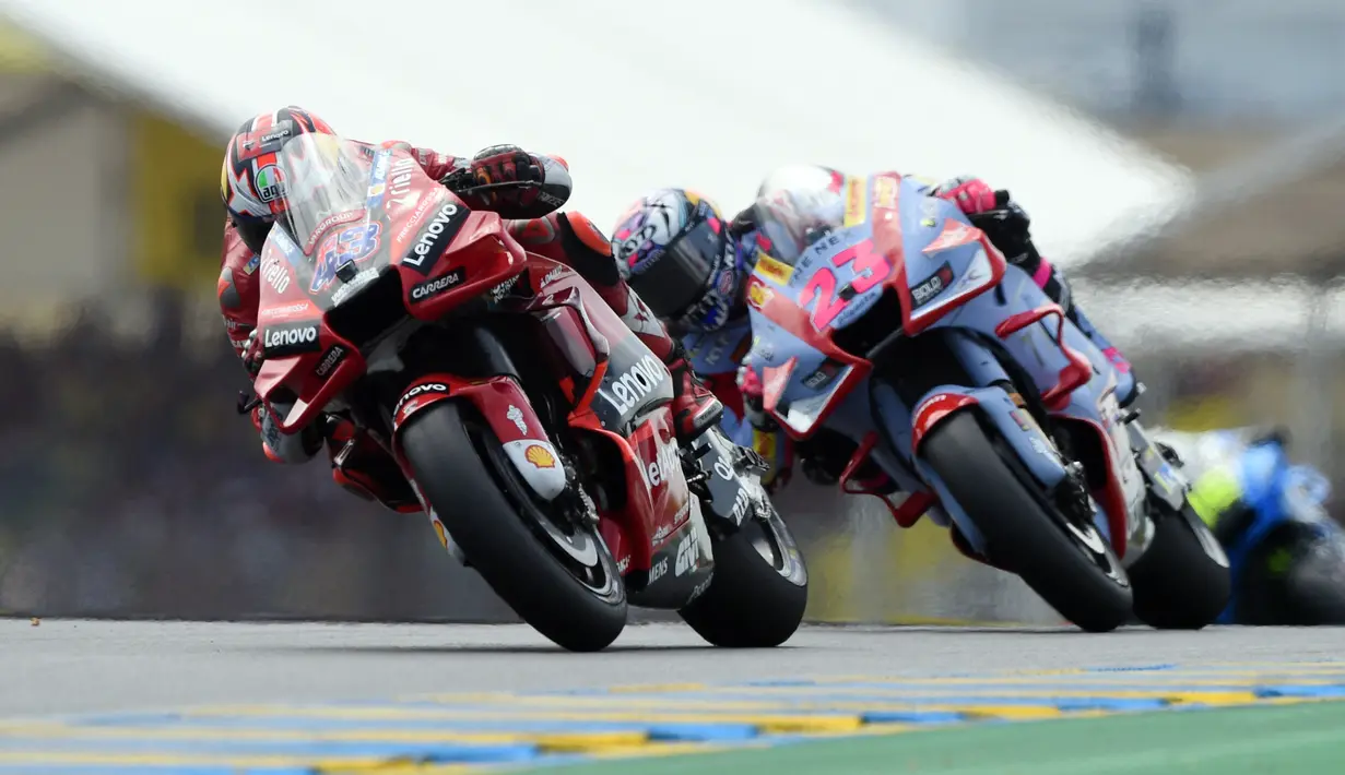Pembalap Ducati Lenovo Jack Miller mengendarai motornya di depan pembalap Gresini Racing Enea Bastianini pada MotoGP Prancis 2022 di Sirkuit Bugatti, Le Mans, Prancis, 15 Mei 2022. Enea Bastianini berhasil menang dramatis di MotoGP Prancis 2022. (JEAN-FRANCOIS MONIER/AFP)