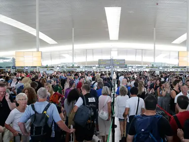 Ribuan penumpang menunggu untuk melewati kontrol keamanan di bandara Barcelona di Prat Llobregat, Spanyol  (4/8). Mogok kerja para staf keamanan bandara yang berlangsung hampir dua jam. (AP Photo / Manu Fernandez)