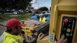 Masalah ini disebabkan oleh kapasitas yang terbatas dan sering terjadi penumpukan sampah, meskipun ada upaya daur ulang yang sedang dilakukan. Tampak dalam foto, pekerja pemerintah daerah mengumpulkan bahan daur ulang di desa Acharavi, pulau Corfu, pada 15 Oktober 2025. (Angelos TZORTZINIS/AFP)