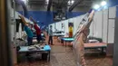 Seorang dokter yang mengenakan setelan Alat Pelindung Diri memberikan instruksi kepada pasien saat melakukan yoga di dalam bangsal di kompleks olahraga Commonwealth Games (CWG) Village yang sementara diubah menjadi pusat perawatan Covid-19 di New Delhi, India, Kamis (16/7/2020). (Money SHARMA / AFP)