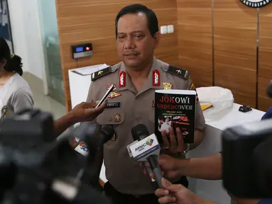 Kabagpenum Polri Brigjen Rikwanto menunjukkan buku Jokowi Undercover saat memberikan keterangan pers di Kadivhumas Polri, Jakarta, Selasa (3/1). (Liputan6.com/Johan Tallo)