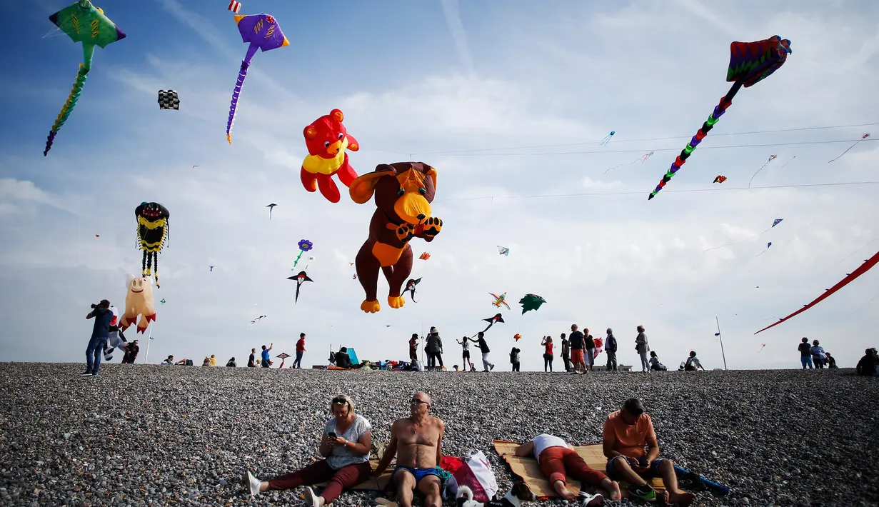 Orang-orang menerbangkan layang-layang selama Festival Layang-layang Internasional Dieppe ke-20 di Dieppe, Prancis, Minggu (9/9). Festival setiap dua tahun sekali sejak 1980 itu menjadi festival layang-layang terbesar di Eropa. (AFP/CHARLY TRIBALLEAU)