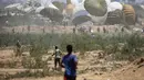 Warga Palestina bergegas menuju lokasi pendaratan paket bantuan yang diterjunkan di wilayah Nuseirat, Jalur Gaza tengah, saat penerjunan bantuan dari udara di atas wilayah Palestina yang dikepung Israel pada 6 Agustus 2025. (Eyad BABA/AFP)