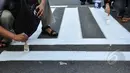 Suasana pengecatan jalur zebra cross di depan Stasiun Sudirman, Jakarta, Jumat (13/3/2015). (Liputan6.com/Faizal Fanani)