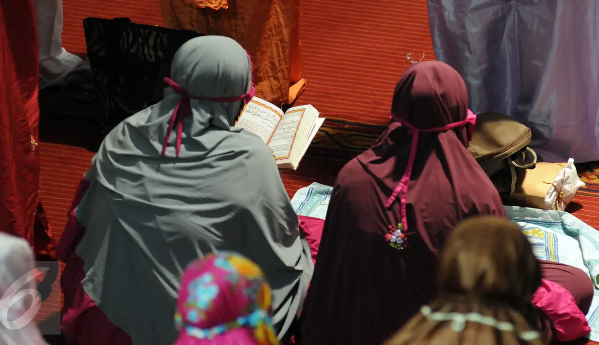 Jamaah muslimah membaca Al Quran di sela sela menunaikan shalat tarawih pertama Ramadan 1437 H di masjid Istiqlal, Jakarta, Minggu (5/6/2016). Berdasar, hasil sidang isbat ditetapkan 1 Ramadan jatuh pada Senin (6/6/2016). (Liputan6.com/Helmi Fithriansyah)