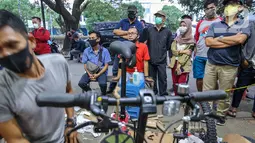 Warga antre menunggu pesanan sepeda yang sedang dirakit di Toko Sepeda Maju Royal, Cipondoh, Kota Tangerang, Kamis (11/6/2020). Menjelang new normal, toko sepeda yang buka sepada pukul 16.00 - 01.00 dinihari mulai diburu warga yang mencari sepeda lipat. (Liputan6.com/Fery Pradolo)