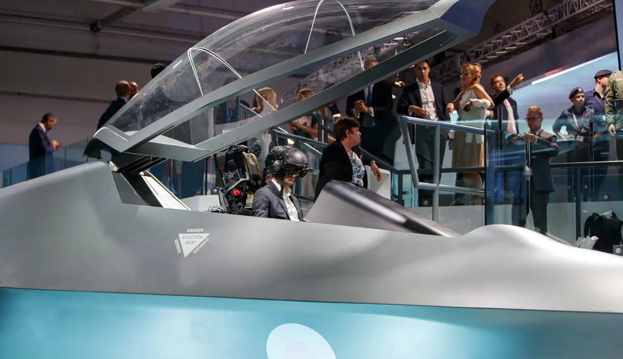 Pengunjung berada di jet tempur baru 'Tempest' milik Inggris selama Farnborough Airshow di London, Inggris (16/7). Jet tempur Tempest akan mulai digunakan militer Inggris tahun 2035 mendatang karena masih dalam pengembangan. (AFP Photo/Tolga Akmen)
