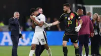 Kiper Spanyol Unai Simon memberikan Jude Bellingham semangat usai Inggris kandas 1-2 pada partai final Euro 2024 hari Senin (15/07/2024) dini hari WIB. (Adrian DENNIS / AFP)