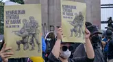 Para mahasiswa menunjukkan plakat bertuliskan “Kembalikan Tentara ke Barak” dalam sebuah protes menentang Revisi Undang-Undang Tentara Nasional Indonesia (RUU TNI) di depan gedung DPR di Jakarta pada tanggal 20 Maret 2025. (BAY ISMOYO/AFP)