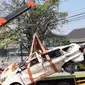 Petugas derek mengevakuasi bangkai mobil kecelakaan maut yang hancur tertindih badan truk muatan tanah di Karawaci, Tangerang, Kamis (1/8/2019). Lima orang penumpang minibus menjadi korban, empat diantaranya meninggal dan satu balita berhasil diselamatkan warga. (Liputan6.com/Pramita Tristiawati)