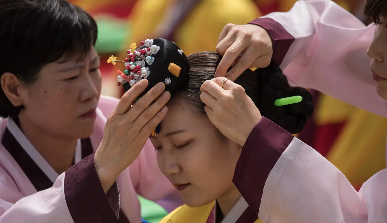 Seorang pelajar mempersiapkan diri sebelum mengikuti upacara Coming of Age Day di Namsan Hanok Village, Seoul, Senin (15/5). Upacara Hari Kedewasaan adalah hari libur resmi untuk menghormati siapa saja yang baru menginjak usia 20 tahun. (Ed JONES/AFP)