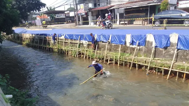 Satgas DPUPR melakukan perbaikan trotoar yang ambles di Jalan Raya Sawangan, Depok. (Liputan6.com/Dicky Agung Prihanto)