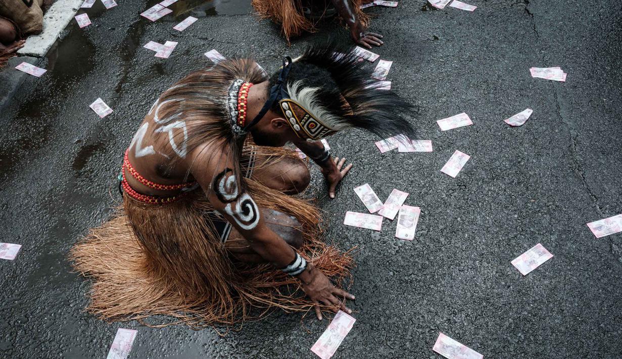 Presiden Prabowo mengatakan penanaman di Papua bertujuan untuk swasembada energi dan pangan. Tampak dalam foto, aktivis Greenpeace Indonesia dan bersama beberapa pemuda Papua menggelar aksi teatrikal saat berunjuk rasa di depan Kantor Kementerian Koordinator bidang Perekonomian, Jakarta, Kamis (18/12/2025). (Yasuyoshi Chiba/AFP)