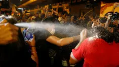 Polisi menggunakan semprotan merica untuk menghadapi pengunjuk rasa yang berdemonstrasi di Hong Kong, Minggu (6/10). Massa menentang intervensi Bejing untuk melarang dua aktivis pro-kemerdekaan menjabat sebagai anggota parlemen. (REUTERS/Tyrone Siu)