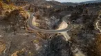 Pemandangan udara ini menunjukkan sebuah jalan yang membentang di sepanjang lahan yang terbakar akibat kebakaran hutan di dekat desa Jonquieres, di departemen Aude, Prancis Selatan, pada 18 Agustus 2025. (Lionel BONAVENTURE/AFP)