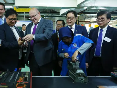 Menteri Ekonomi dan Energi Jerman Peter Altmaier (tengah), Menperin Airlangga Hartarto, Presdir PT Astra International Tbk Prijono Sugiarto melihat komponen di workshop Politeknik Manufaktur Astra, Jakarta, Kamis (1/11). (Liputan6.com/Pool/Mulawarman)