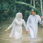 Pasangan ini mengabadikan momen pernikahannya di sederet foto saat banjir. (dok. Facebook @Meen Photographer)