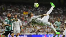 Kapten Real Madrid, Sergio Ramos melakukan tendangan salto saat timnya menang besar 5-0 atas Real Betis Balompie  pada laga La Liga Spanyol di Stadion Santiago Bernabeu, Madrid, (29/8/2015). (AFP Photo/Pierre-Philippe Marcou)