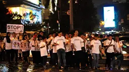 Para peserta aksi mengelilingi Bundaran HI dengan membawa lilin di tangan, Jakarta, Kamis (20/11/2014). (Liputan6.com/Faisal R Syam) 
