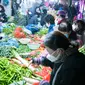 Orang-orang berbelanja sayuran di sebuah pasar di Wuhan, Provinsi Hubei, China, Kamis (23/1/2020). Pemerintah China mengisolasi Kota Wuhan yang berpenduduk sekitar 11 juta jiwa untuk menahan penyebaran virus corona. (Xiao Yijiu/Xinhua via AP)