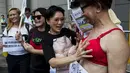 Pengunjuk rasa memakai bra di luar markas polisi di kawasan Wan Chai, Hong Kong, Minggu (2/8). Demo tersebut merupakan aksi simpati terhadap seorang perempuan yang di penjara karena dituduh menyerang polisi menggunakan payudaranya. (REUTERS/Tyrone Siu)