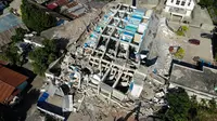 Petugas membersihkan puing-puing dari hotel Roa Roa yang runtuh di Palu, Sulawesi Tengah, Senin (1/10). Jumlah korban tewas akibat gempa dan tsunami yang melanda Palu dan Donggala diperkirakan akan meningkat. (JEWEL SAMAD/AFP)
