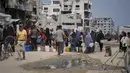 Di tengah panas terik musim panas, warga Palestina mengantre untuk mengambil air dari titik distribusi di Kota Gaza, Selasa 12 Agustus 2025. (AP Photo/Jehad Alshrafi)