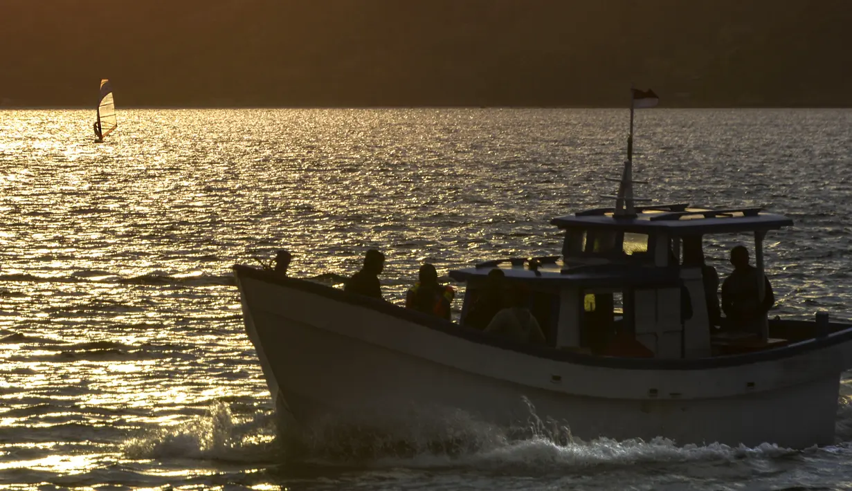 Sebuah perahu nelayan kembali ke pantai setelah memancing saat matahari terbenam di pantai di Banda Aceh (7/4). Kota Banda Aceh merupakan salah satu kota yang berada di Aceh dan menjadi ibukota Provinsi Aceh, Indonesia. (AFP Photo/Chaideer Mahyuddin)