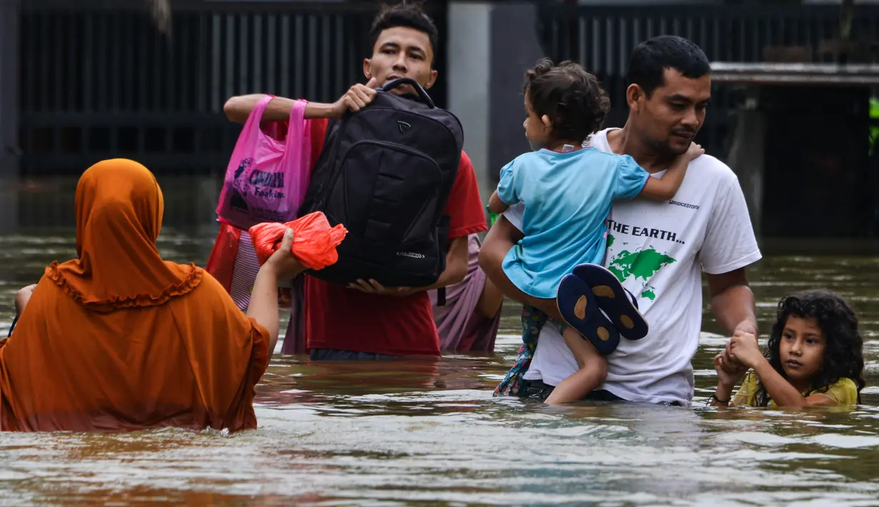 Seorang pria dan anaknya menerebos banjir setelah tiga hari diguyur hujan lebat di Banda Aceh, Aceh, Sabtu (9/5/2020). Banjir akibat intensitas hujan tinggi tersebut mengakibatkan sebagian besar kawasan di ibu kota Provinsi Aceh ini digenangi air. (Photo by CHAIDEER MAHYUDDIN/AFP)