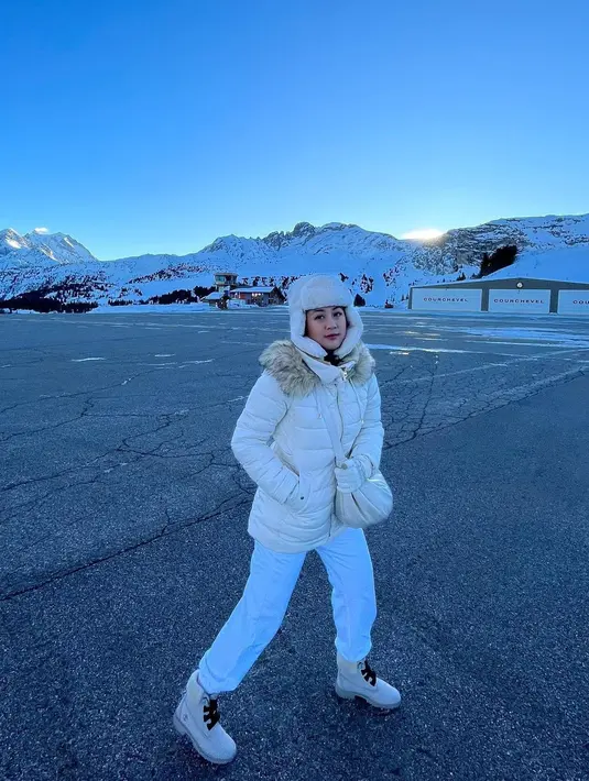 OOTD kece Sherina Munaf liburan di Eropa dengan puffer jacket dan topi berbulu serba putih. [@sherinamunaf]