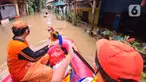 Petugas PPSU membawa bantuan nasi bungkus untuk warga yang bertahan saat banjir di kawasan pemukiman Jalan Bango, Pondok Labu, Jakarta Selatan, Sabtu (20/2/2021). Banjir akibat luapan Kali Krukut yang melanda sejak semalam menyebabkan pemukiman tergenang hingga dua meter. (merdeka.com/Arie Basuki)