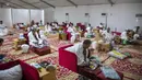 Jemaah makan dalam kamp saat melaksanakan rangkaian ibadah haji di Kota Suci Makkah, Arab Saudi, Kamis (30/7/2020). Hanya sekitar seribu jemaah yang diizinkan untuk melakukan ibadah haji tahun ini karena pandemi COVID-19. (Saudi Ministry of Media via AP)