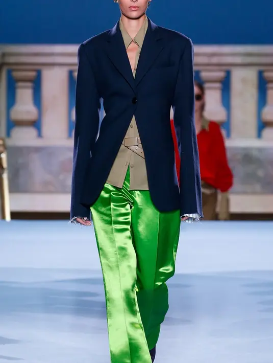 Jas biru yang dipadankan dengan kemeja cut out dan long pants satin berwarna hijau beri kesan chic pada penampilan formal. [Dok/ToryBurch]