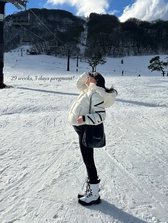 Jessica Mila tampil dengan padding jaket putih dipadukan celana hitam serasi dengan tas Chanelnya. Serta sepatu boots putih. [@jscmila]