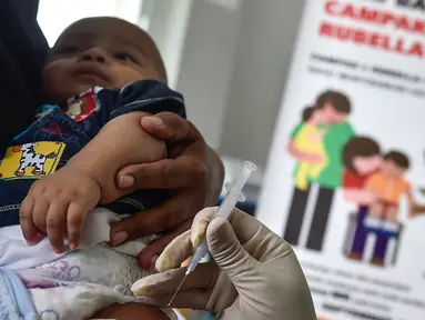 Petugas menyuntikan Vaksin Campak dan Rubella (MR) kepada bayi saat dilakukan imunisasi di sebuah puskesmas, Banda Aceh, Rabu (19/9). Pemprov Aceh akhirnya membolehkan pelaksanaan vaksinasi MR yang mengandung enzim babi. (CHAIDEER MAHYUDDIN / AFP)