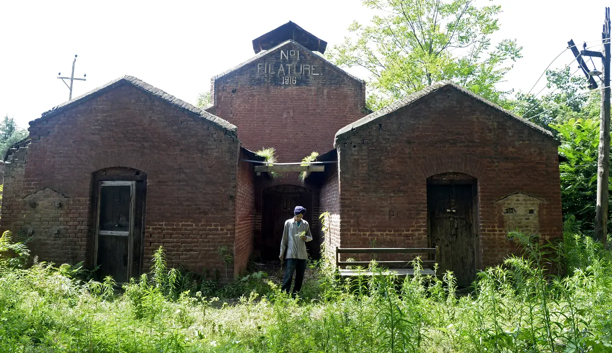 Pekerja berdiri di luar pabrik sutra tertua di Srinagar, Kashmir, India, Senin (30/7). (Tauseef MUSTAFA/AFP)