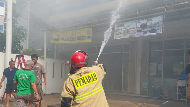 Pemadam kebakaran tengah memadamkan api yang melalap Indomaret di di Jalan Kramat 4 Senen, Jakarta Pusat.